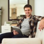 portrait-relax-tablet-with-man-sofa-living-room-home-app-browsing-social-media-internet-smile-technology-with-happy-person-apartment-comfort-weekend-time-off_590464-376161